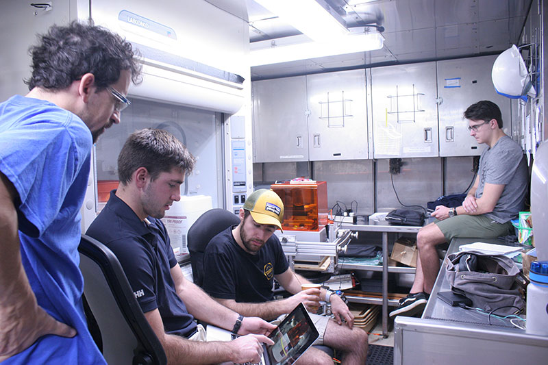 Josh, Sean, Grady, and Professor Licht looking over time-lapse footage of the 3D printer.
