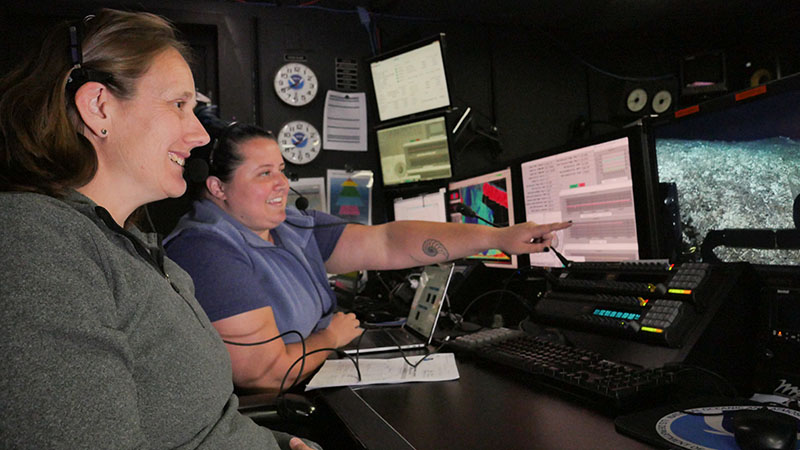 Expedition science leads Amy Wagner (left) and Alexis Weinnig (right) in the control room on NOAA Ship Okeanos Explorer reviewing the footage during a remotely operated vehicle dive of Windows to the Deep 2019 expedition.