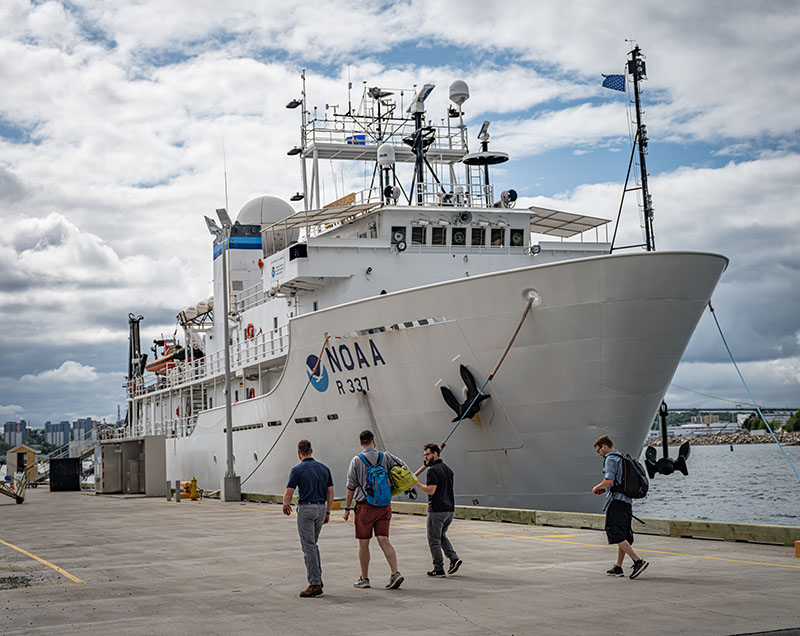 A filmmaker (third from right) speaks with Science Lead Jeff Obelcz upon his arrival at port.