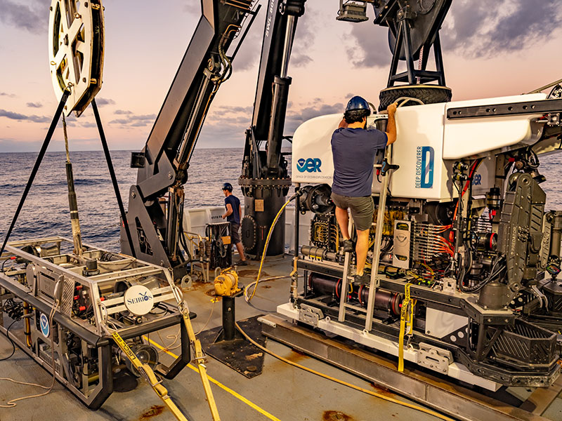 Remotely operated vehicles Deep Discoverer and Seirios make up the dual-bodied system that will be used to conduct visual surveys of the seafloor during the 2021 North Atlantic Stepping Stones expedition. In this image, the vehicles are being prepared for launch off NOAA Ship Okeanos Explorer during the 2019 Southeastern U.S. Deep-sea Exploration.