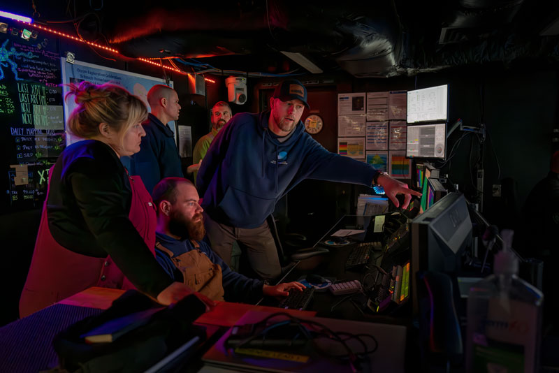 2023 Shakedown + EXPRESS: West Coast Exploration expedition biology lead Alexis Weinnig, expedition coordinator Thomas Morrow, and Global Foundation for Ocean Exploration team lead Chris Ritter discuss the dive plan for April 23 in the control room on NOAA Ship Okeanos Explorer.