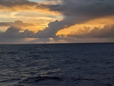 The sun peeks through the clouds over the Pacific Ocean during the Beyond the Blue: Hawai‘i Mapping expedition on NOAA Ship Okeanos Explorer.