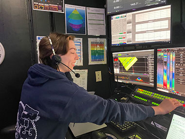 Explorer-in-training Ingrid Martinson monitors the real-time collection of multibeam data from the control room on NOAA
                            Ship <i>Okeanos Explorer</i> during the Seascape Alaska 6 expedition.