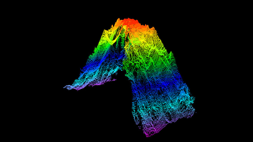 A point cloud of the seamount mapped during the Seascape Alaska 1: Aleutians Deepwater Mapping expedition, generated from acoustic data collected via multibeam echosounder. The hot colors (red, orange, and yellow) represent the newly mapped peak of the seamount at a depth of 895 meters (2,936 feet), while the cold colors (purple, teal, blue) represent the base of the seamount at a depth of around 4,000 meters (13,123 feet).