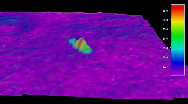 Shipwreck shown colored by slope, indicating surrounding seabed is generally flat with slopes of up to seven degrees. Image created in QPS Fledermaus, vertical exaggeration 3x. Color bar indicates slope of the seabed in degrees.