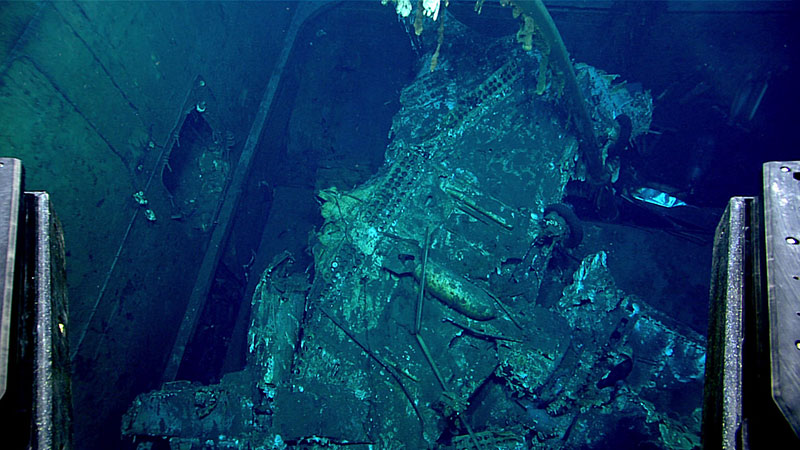 Underwater aircraft wreckage with twisted metal and damaged components.